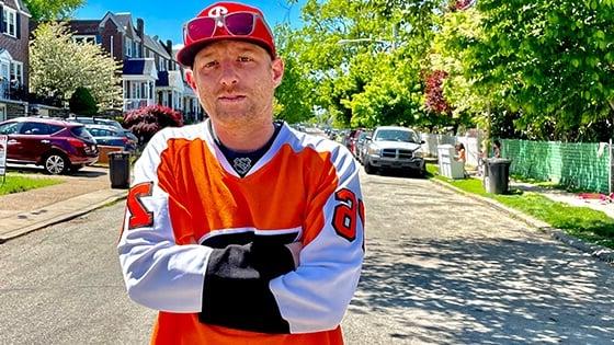 满帆 电影 Production MFA grad Panda Lord in an orange hockey jersey on a residential Philadelphia street.