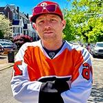满帆 电影制作硕士 grad Panda Lord in an orange hockey jersey on a residential Philadelphia street.